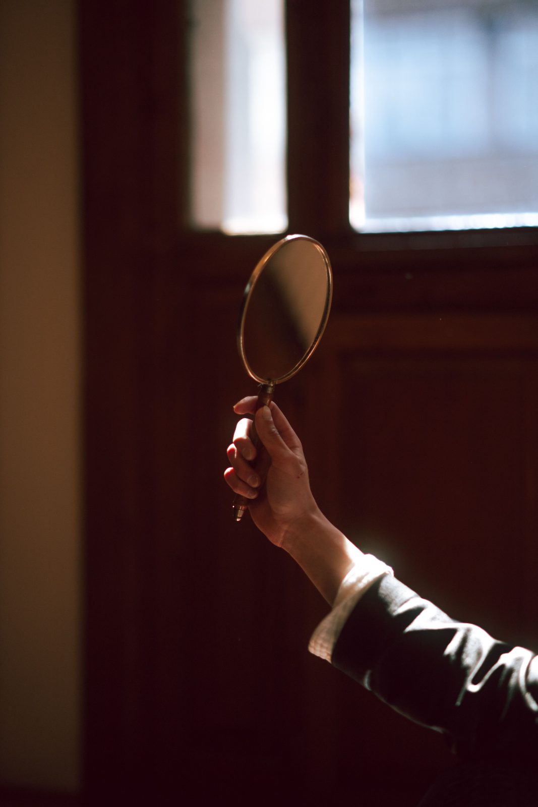 A hand mirror resting on fabric