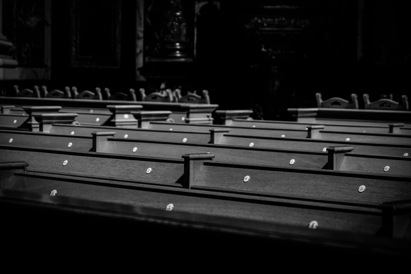 Empty wooden pews in black and white